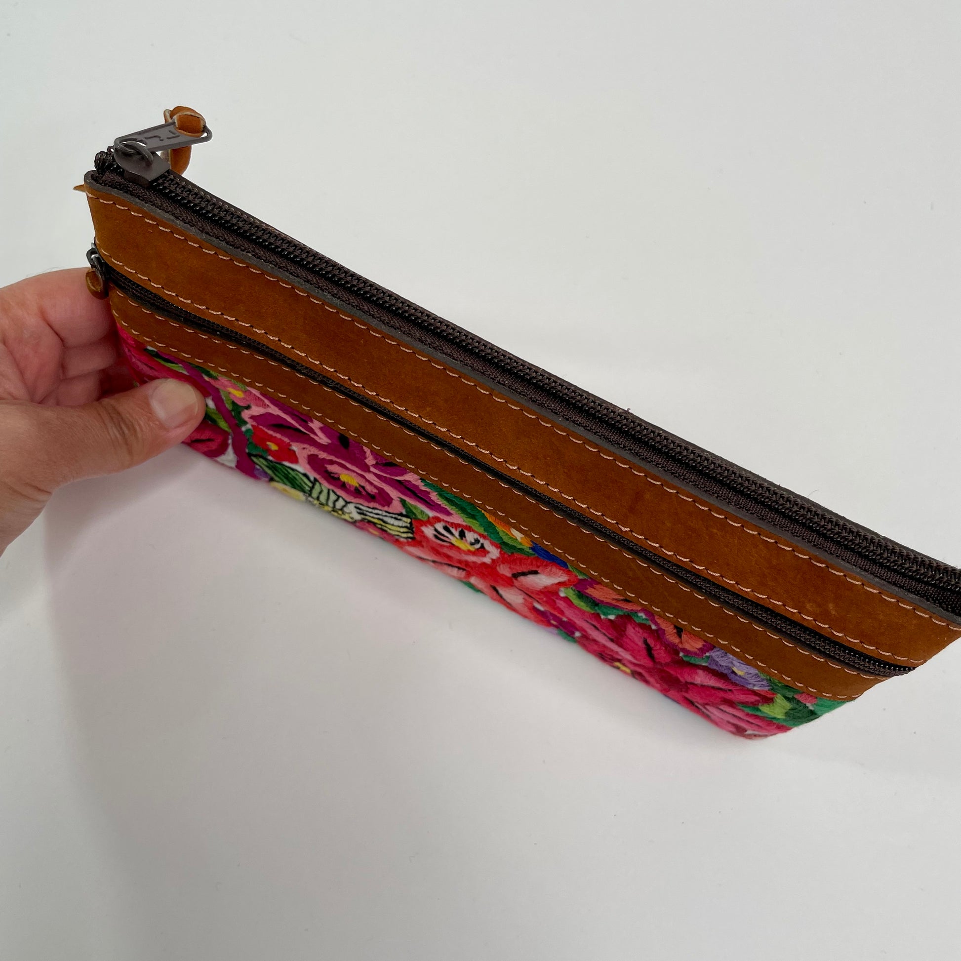 Cosmetic pouch is created with repurposed Mayan blouse material and Nubuck leather.