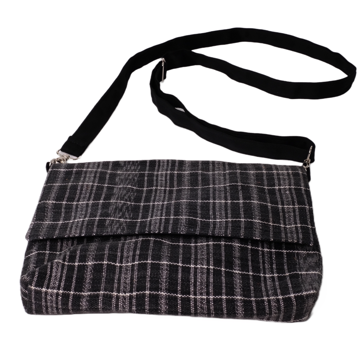 Crossbody bag is constructed with carefully handwoven black ikat cotton textiles.
