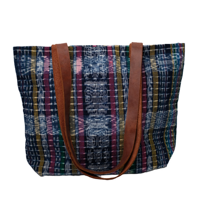 A tote made with colorful handwoven fabric from Guatemala with leather straps.