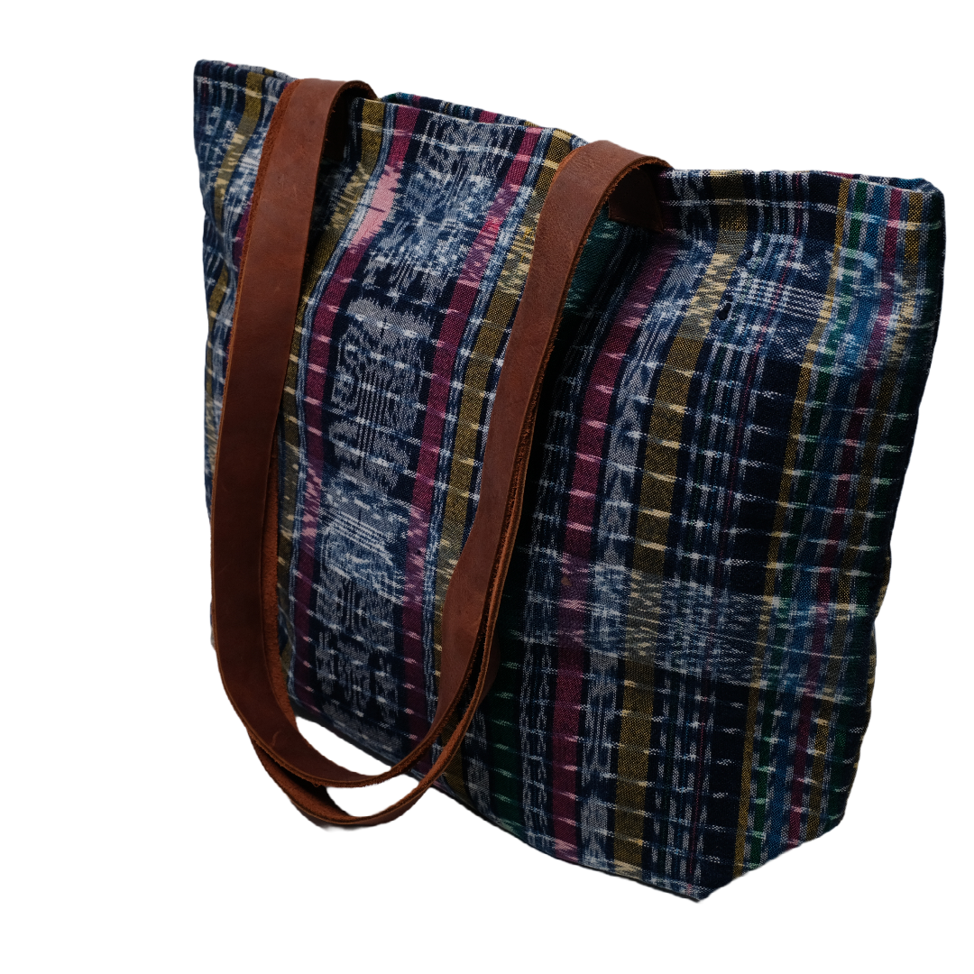 A tote made with colorful handwoven fabric from Guatemala with leather straps.