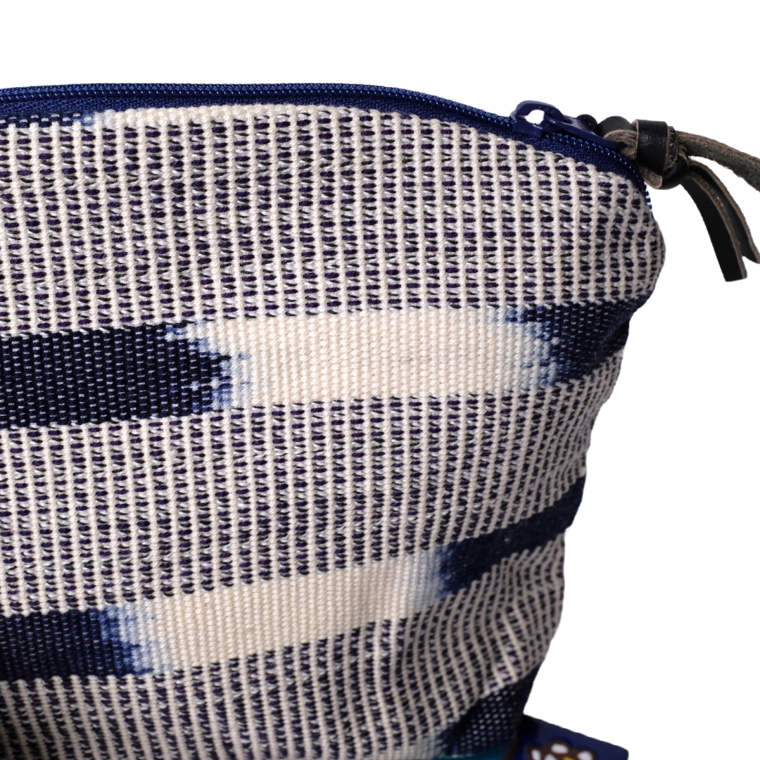 A small bag made with hand-woven fabric and ikat pattern.