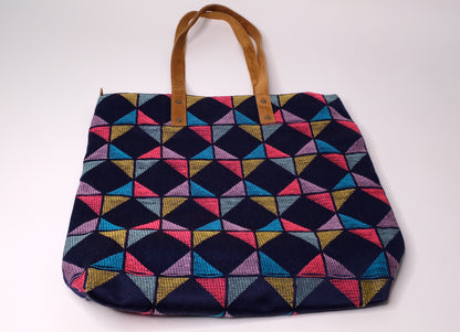 Tote bag crafted from recycled fabric and suede.