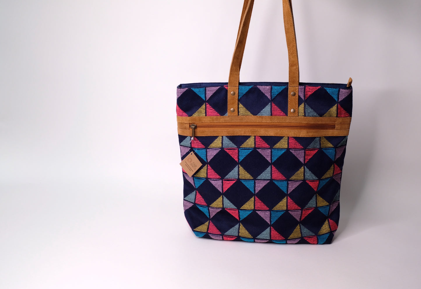 Tote bag crafted from recycled fabric and suede.