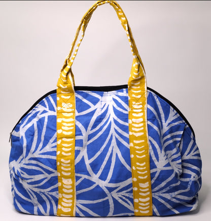 Large zippered weekend bag with a blue plant pattern and yellow straps.
